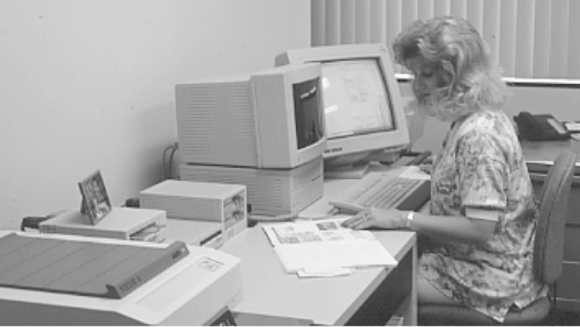 Black and white photo of a woman working on a computer